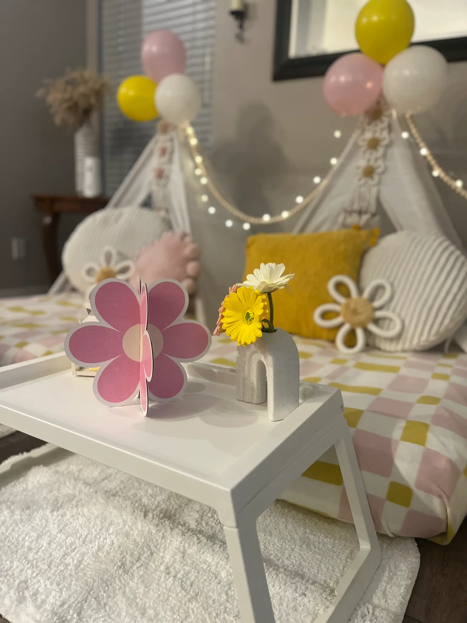 Daisy themed sleepover setup with teepees and fairy lights
